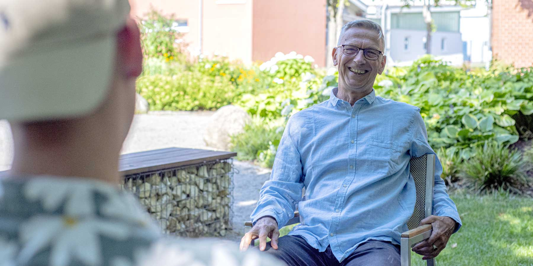 Portrait von Uwe Kreß, Trainer und Mentor für sensible Menschen, freundlich lächelnd im Freien im Gespräch mit einem Klienten.