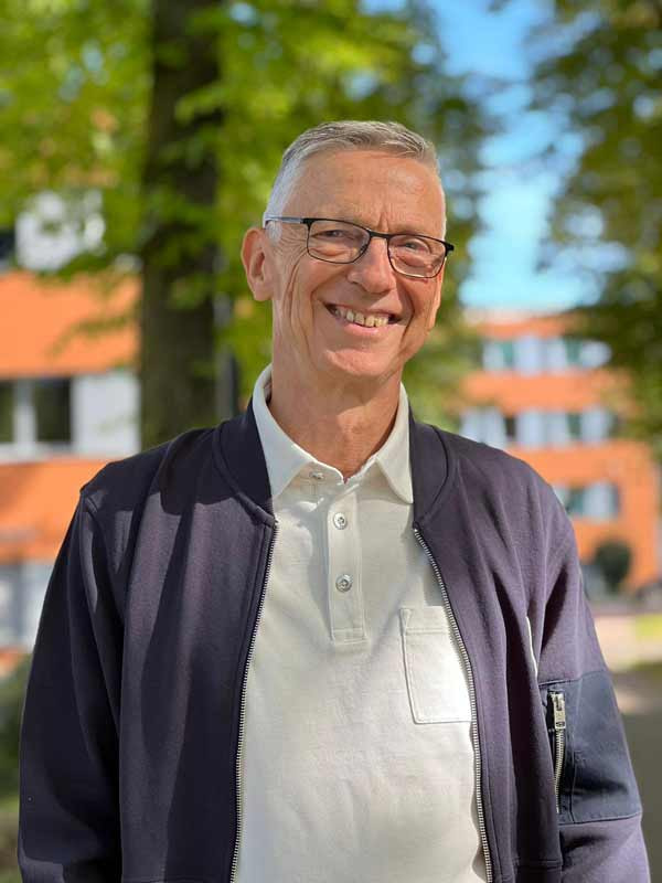 Götz Uwe Kreß – Klarheit und Erfahrung Portrait von Uwe Kreß, Trainer und Mentor, freundlich lächelnd im Freien vor einem Gebäude – Symbol für Klarheit, Professionalität und Vertrauen.