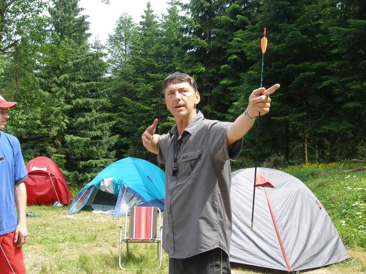 Der Moment vor dem Durchbruch Trainer Götz Uwe Kreß steht in einem Zeltlager im Wald und erklärt einer Gruppe mit einem Pfeil in der Hand eine Übung zur Persönlichkeitsentwicklung.