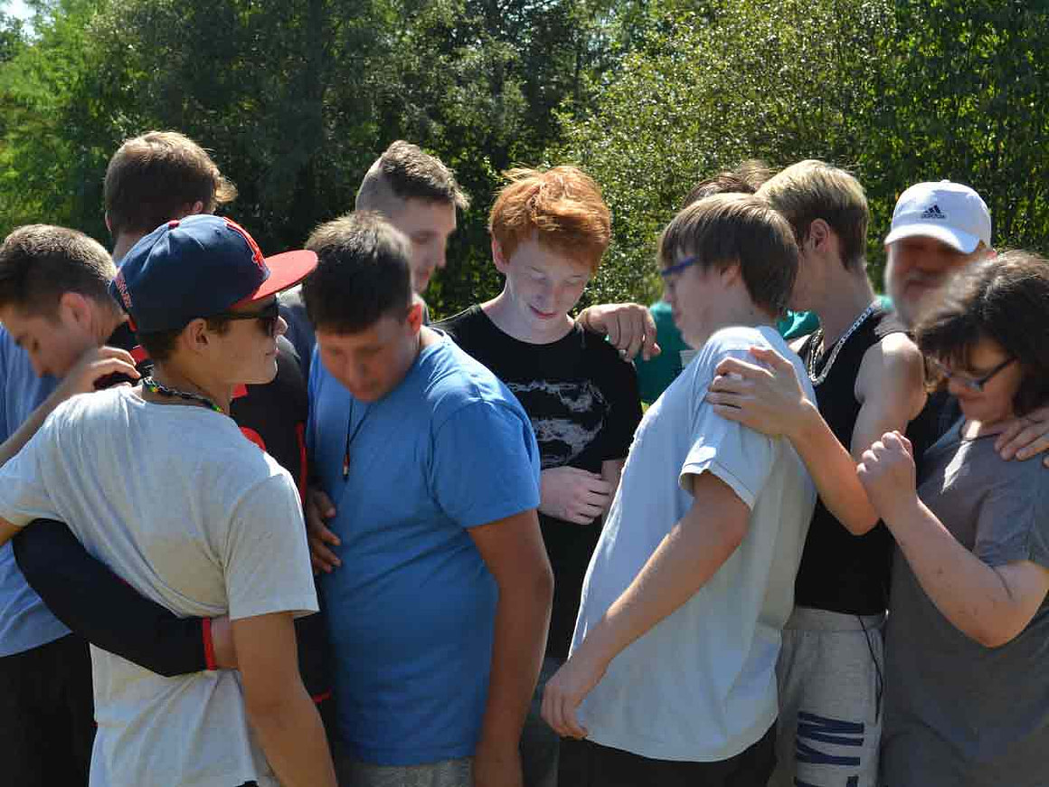 Lebendige Gruppenarbeit durch kreative Methoden Gruppe von Auszubildenden in fröhlicher Stimmung bei einer Teamübung im Freien – lebendige Gruppenarbeit durch kreative Methoden.
