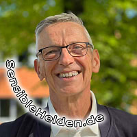 Porträtfoto von Götz Uwe Kreß, Mentor für sensible Helden. Er hat kurze graue Haare, trägt eine Brille und lächelt freundlich und zugewandt in die Kamera.